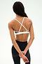 A person stands with their back to the camera, wearing the SPLITS59 Sage Rigor Bra in Black/White and black nylon-spandex leggings. Their hands are clasped behind their back.