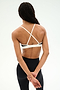 A person stands with their back to the camera, wearing the SPLITS59 Sage Rigor Bra in Black/White and black nylon-spandex leggings. Their hands are clasped behind their back.