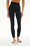 A person is shown from the waist down against a white background, wearing SPLITS59 Clare High Waist Rigor 7/8 leggings in Black/White—expertly crafted from rigor fabric for gym workouts—and white athletic shoes accented with black stripes.
