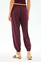 A person is seen from the back wearing SPLITS59 Andie Oversized Fleece Sweatpant in Dk Cherry and beige sneakers with maroon stripes, set against a plain white background.