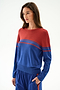 Woman wears the SPLITS59 Anna Knit Pullover - Cobalt/Terracotta with blue pants, standing against a plain white background.