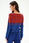 Woman faces away, wearing the SPLITS59 Anna Knit Pullover - Cobalt/Terracotta with red top, blue bottom, two red stripes, and blue pants.