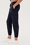 A person wearing SPLITS59 Supplex Cargo Pant - Black and white sneakers stands with hands in their pockets against a plain white background.