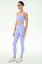 A woman models the SPLITS59 Airweight High Waist 26" leggings in Purple Haze—a light purple, stretchy sports bra and high-waisted legging set—standing against a plain white background, facing slightly to the side.