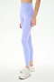 Model wearing SPLITS59 Airweight High Waist 26" leggings in Purple Haze and white athletic shoes, against a plain white background. Only the lower torso and legs are visible.