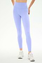 A person wears SPLITS59 Airweight High Waist 26" leggings in Purple Haze with white sneakers, standing against a plain white background.