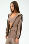 A woman models the SPLITS59 Reggie Water Repellent Jacket in Latte/Black over matching activewear, standing against a plain background.