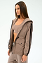 A woman models the SPLITS59 Reggie Water Repellent Jacket in Latte/Black over matching activewear, standing against a plain background.