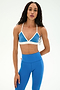 A woman with long hair stands against a plain light background, wearing the SPLITS59 Sage Rigor Bra in Classic Blue/White along with matching blue leggings, both crafted from stretchy nylon spandex fabric.