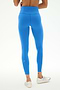 A person is shown from the back against a light background, wearing SPLITS59’s Clare High Waist Rigor 7/8 leggings in Classic Blue/White, made from a smooth nylon-spandex fabric, paired with white athletic shoes.