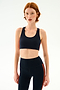 A person wearing an Ella Airweight Bra - Indigo/Valencia and matching leggings in a stretchy athletic fabric with orange side stripes.