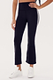 Person wearing SPLITS59 Raquel High Waist Crop - Black/White, made from 88% Nylon and Spandex blend, paired with white sneakers, standing against a plain white background.
