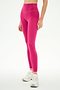 Person wearing SPLITS59 Airweight High Waist 26" leggings in Sangria, made from a comfy nylon-spandex blend, paired with white sneakers and standing against a plain white background.