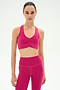A woman faces forward in SPLITS59’s Airweight Bra with Ruching in Sangria, paired with matching high-waisted leggings, both crafted from stretch fabric, set against a plain white background.