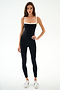 A woman stands against a white background wearing the SPLITS59 Monah Rigor Jumpsuit 7/8 - Black/White and white sneakers.
