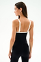 Woman in profile wearing the Monah Rigor Jumpsuit 7/8 - Black/White by SPLITS59, looking left against a plain white background.