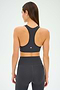 A woman is shown from the back wearing the SPLITS59 Mia Rigor Bra in Graphite and high-waisted athletic leggings against a plain background—an ideal choice for multi-sport performance and intense gym workouts.