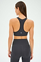 A woman is shown from the back wearing the SPLITS59 Mia Rigor Bra in Graphite and high-waisted athletic leggings against a plain background—an ideal choice for multi-sport performance and intense gym workouts.