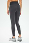 A person is shown from the back against a plain white background wearing SPLITS59 Mia Rigor 7/8 leggings in Graphite, crafted from Rigor fabric, paired with gray sneakers.