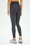 A person is shown from the back against a plain white background wearing SPLITS59 Mia Rigor 7/8 leggings in Graphite, crafted from Rigor fabric, paired with gray sneakers.