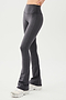 Front side view of woman wearing dark gray high waist below ankle length legging with wide flared bottoms. Paired with white shoes.