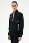 A woman wears the SPLITS59 Lyle Woven Nylon Pullover in Black/Creme with matching black spandex pants, standing against a plain white background.