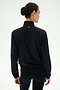 A person with dark hair in a bun is shown from the back against a plain light background, wearing the SPLITS59 Lyle Woven Nylon Pullover in Black/Creme.