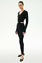 A person stands against a white background wearing the SPLITS59 Bella Airweight Lite Wrap in black, paired with black spandex leggings and black ballet flats.
