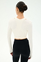 A woman with dark hair in a bun models the SPLITS59 Bella Airweight Lite Wrap in white, standing with her back to the camera against a plain white background.