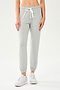 Front view of woman wearing light grey jogger with white drawstring and white cropped tank top paired with creme shoes
