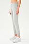 Front side view of woman wearing light grey jogger with white drawstring and white cropped tank top paired with creme shoes