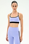 A woman models the SPLITS59 Emerson Airweight Bra in Purple Haze/Black, made from stretch fabric, against a plain white background, highlighting fashionable activewear.