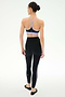 A woman faces away, wearing the SPLITS59 Ella High Waist Airweight 7/8 leggings in Black/Purple Haze with a lilac sports bra and black ballet flats.