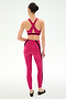 A woman with her hair in a neat bun stands with her back to the camera wearing SPLITS59 Miles High Waist Rigor 7/8 leggings in Sangria/Black and a matching sports bra, paired with black ballet flats.
