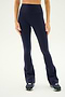 A person wearing the SPLITS59 Raquel High Waist Flared Legging in Indigo and black sneakers stands against a white background.