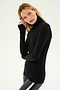 A person with long hair wearing a black Jackson Rib Full Length Turtleneck by SPLITS59 and gray leggings stands against a plain background.