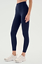 A person wearing SPLITS59's Airweight High Waist Legging in Indigo and white sneakers, standing against a plain background.