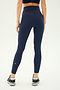 A person wearing the SPLITS59 Airweight Super High Waist 7/8 leggings in indigo and a black sports bra, facing away from the camera. Their feet are clad in athletic shoes with white soles, perfect for hot yoga sessions.