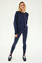 A woman stands against a plain background, wearing the SPLITS59 Sonja Fleece Sweatshirt in Indigo, paired with matching leggings and black sneakers—crafted with care and made in Los Angeles.