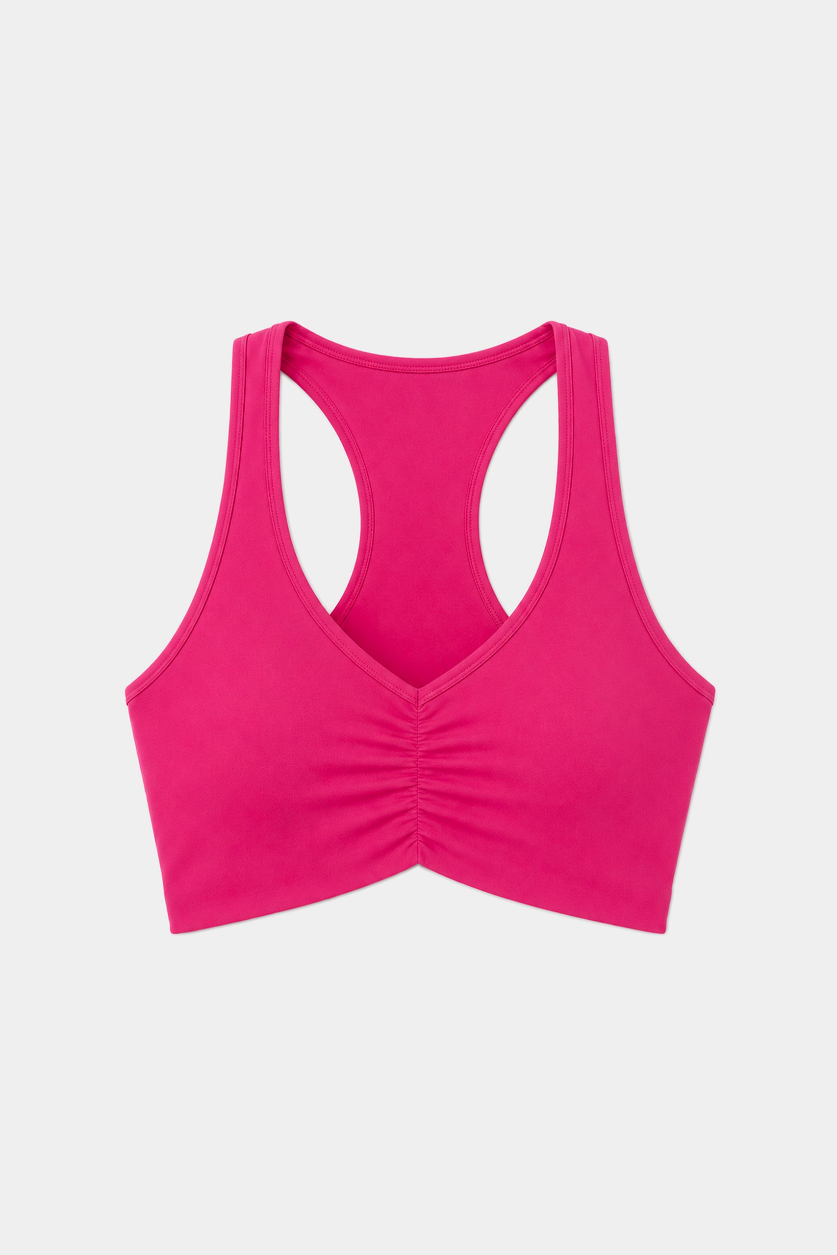 The SPLITS59 Airweight Bra with Ruching in Sangria is a vibrant pink racerback sports bra crafted from stretchy nylon-spandex activewear, featuring a ruched front detail and shown on a plain white background.