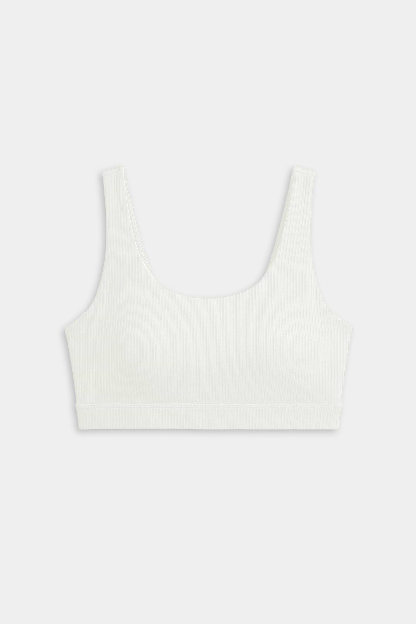 The SPLITS59 Airweight Rib Bra in white features wide straps and a scoop neckline, crafted from ribbed airweight fabric for comfort—ideal for hot yoga. Shown laid flat on a plain light background.