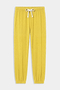 The SPLITS59 Andie Oversized Fleece Sweatpant in Bright Yellow features an elastic waistband, white drawstring, and elastic cuffs—ideal for cool weather workouts. Expertly made in Los Angeles and shown laid flat on a white background.