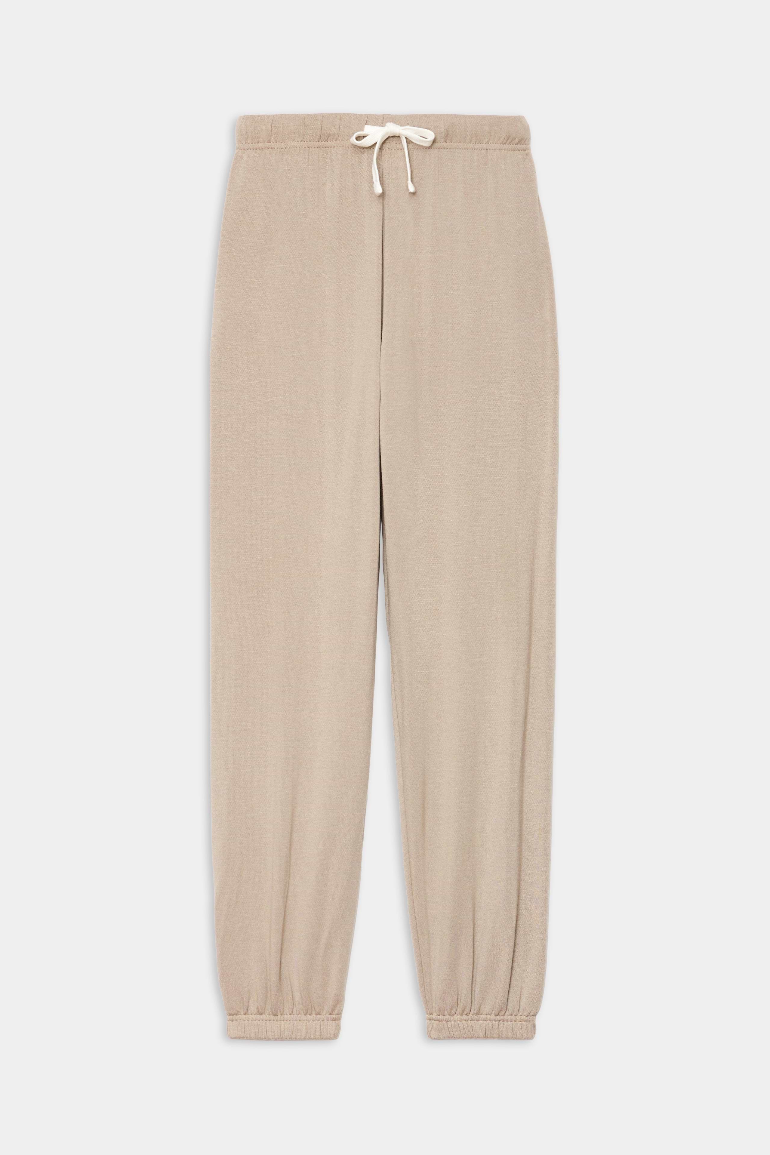 The SPLITS59 Andie Oversized Fleece Sweatpant in Latte features an elasticated waistband and cuffs, perfect for warm-ups or cool weather workouts, shown laid flat on a white background.