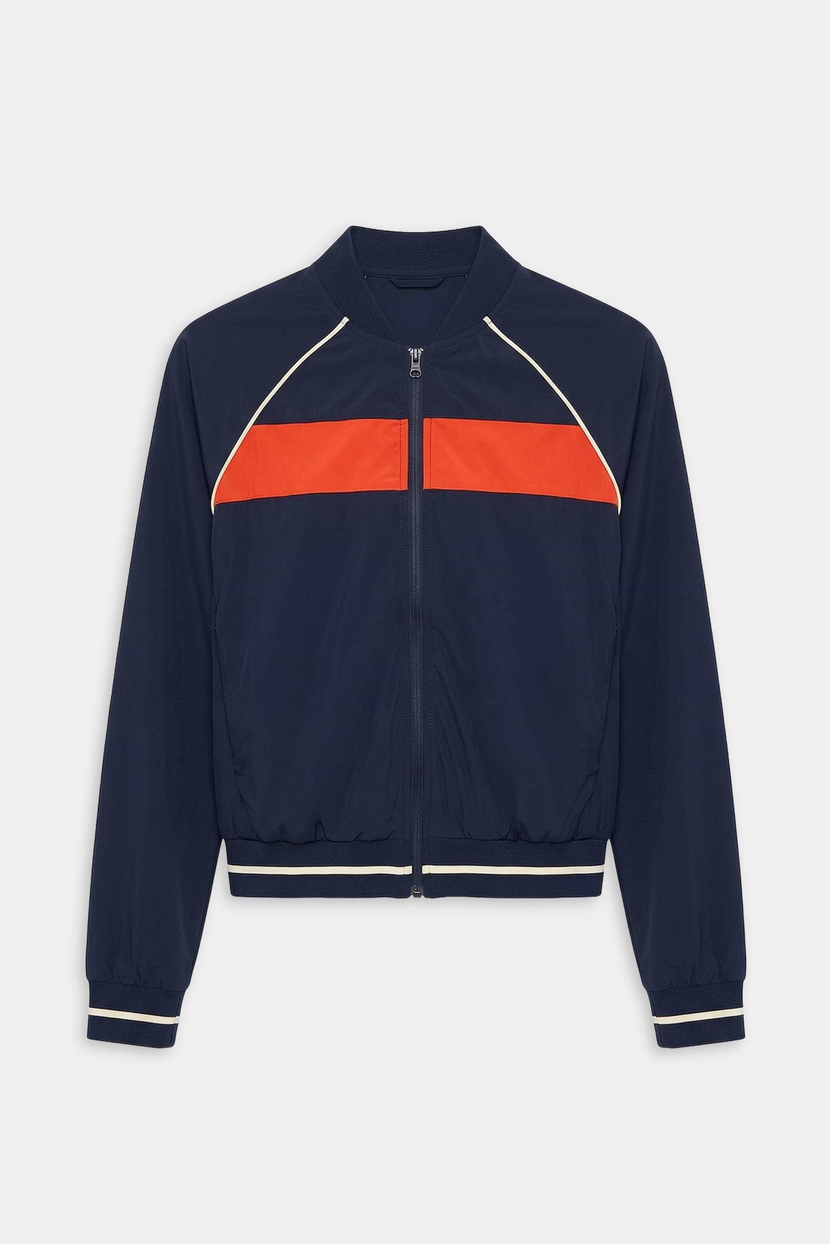 The SPLITS59 Carrie Woven Nylon Jacket in Indigo/Lotus Red features a zip-up design with a bright red chest stripe and white piping on the shoulders and cuffs, crafted from spandex and nylon.