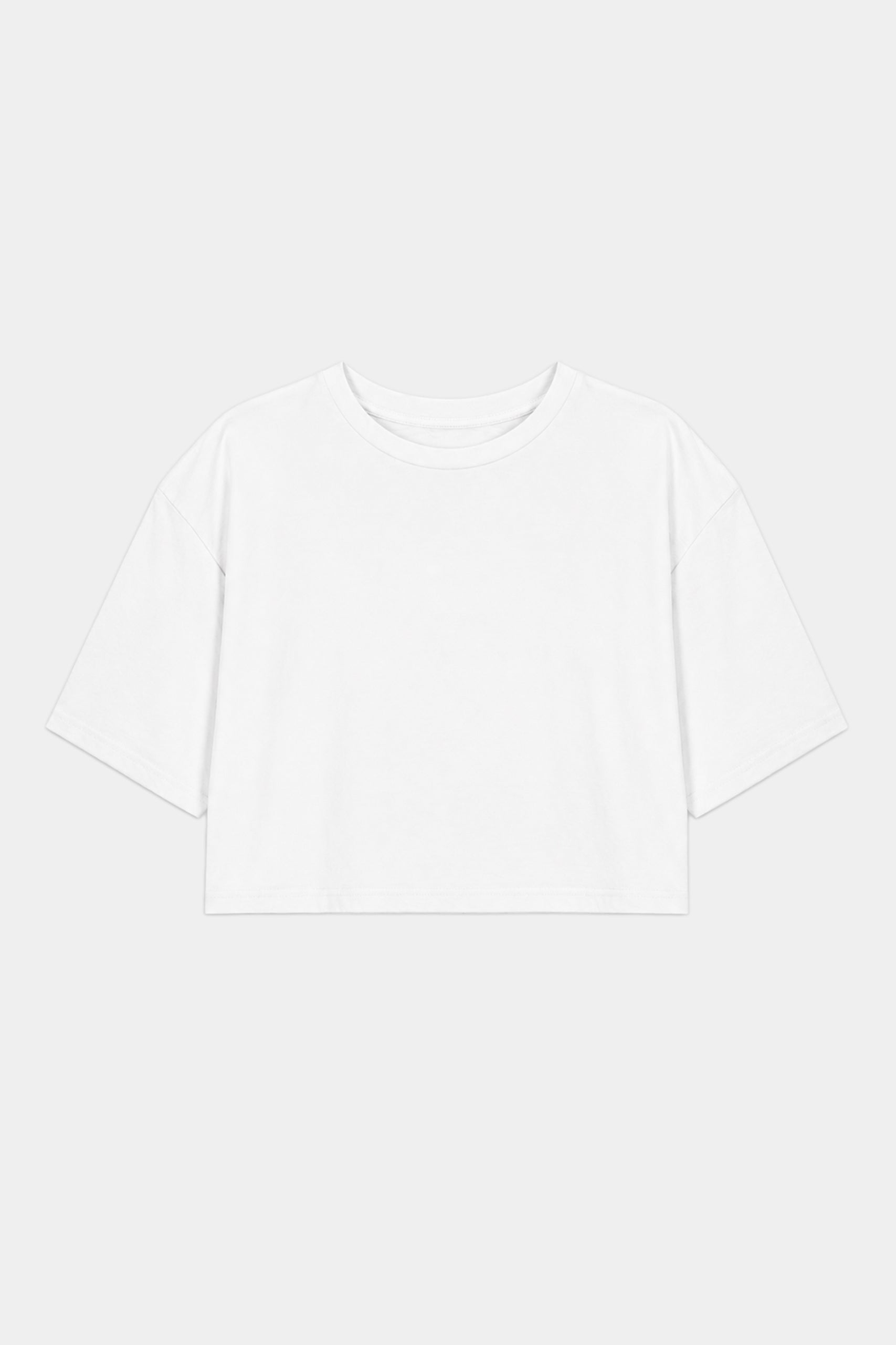 The SPLITS59 Djuna Oversized Crop Jersey Tee in white, a short-sleeve, cropped t-shirt made from a soft spandex blend, is laid flat on a light gray background.