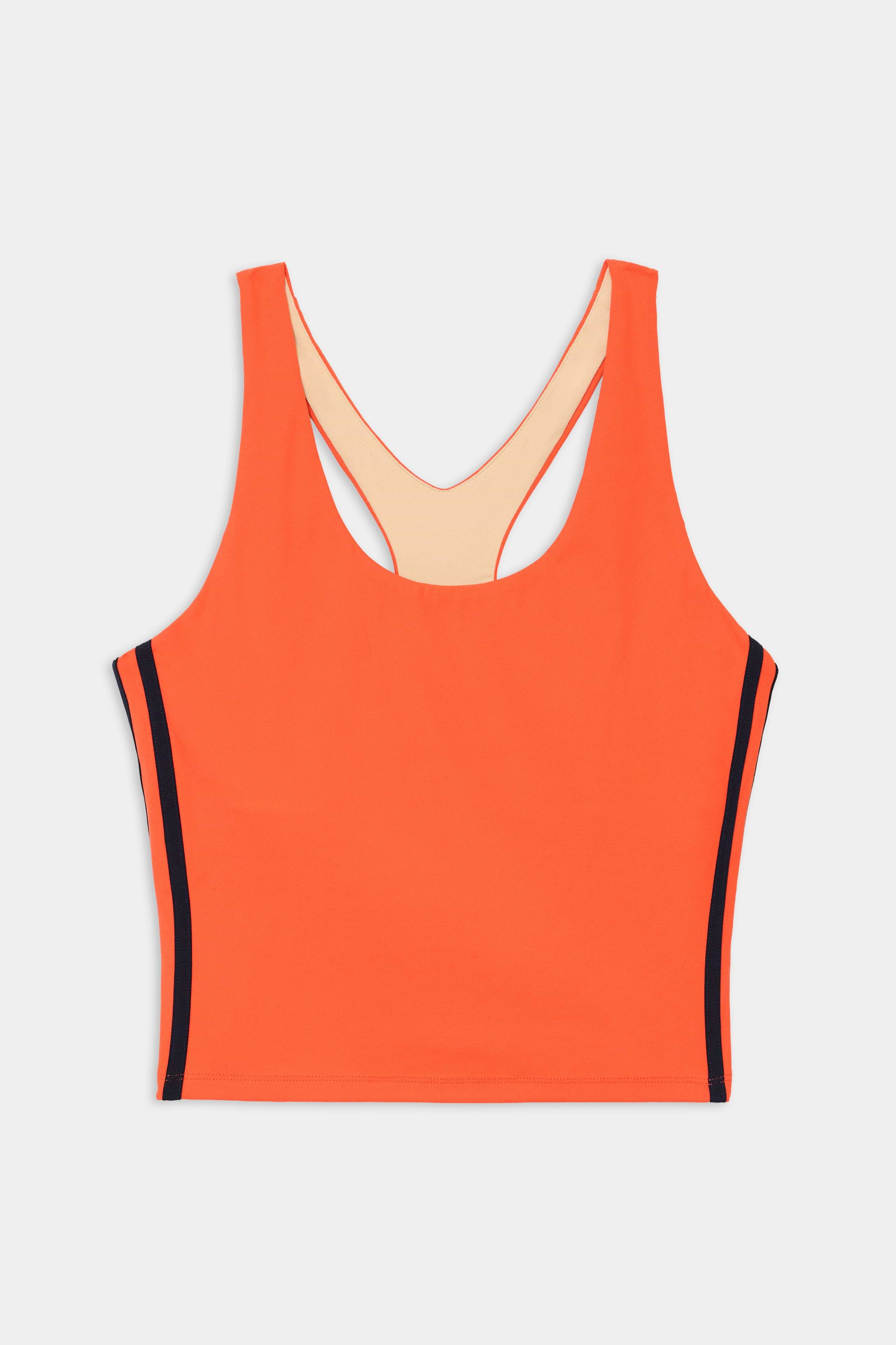 The SPLITS59 Ella Airweight Tank in Valencia/Indigo is an orange athletic crop top with a scoop neck, racerback, and indigo vertical side stripes. Made from stretch fabric, it provides comfort and flexibility for workouts.
