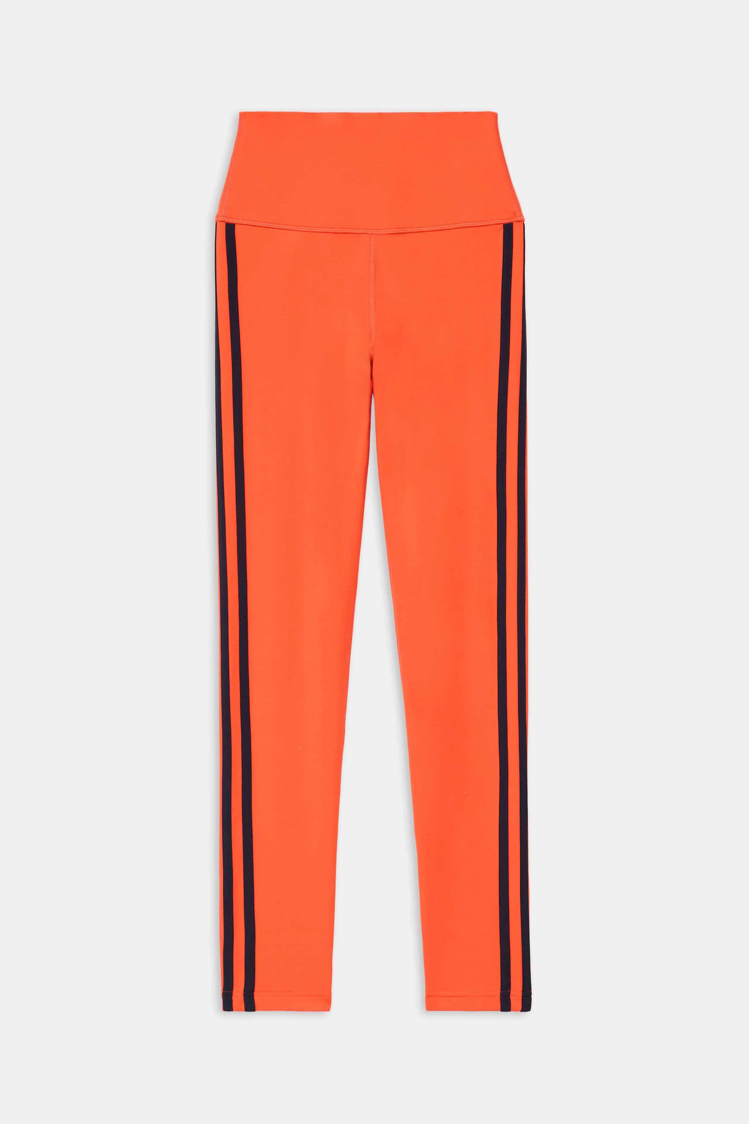 The SPLITS59 Ella High Waist Airweight 7/8 leggings in Valencia/Indigo feature a vibrant orange hue with indigo vertical side stripes, showcased on a white background.