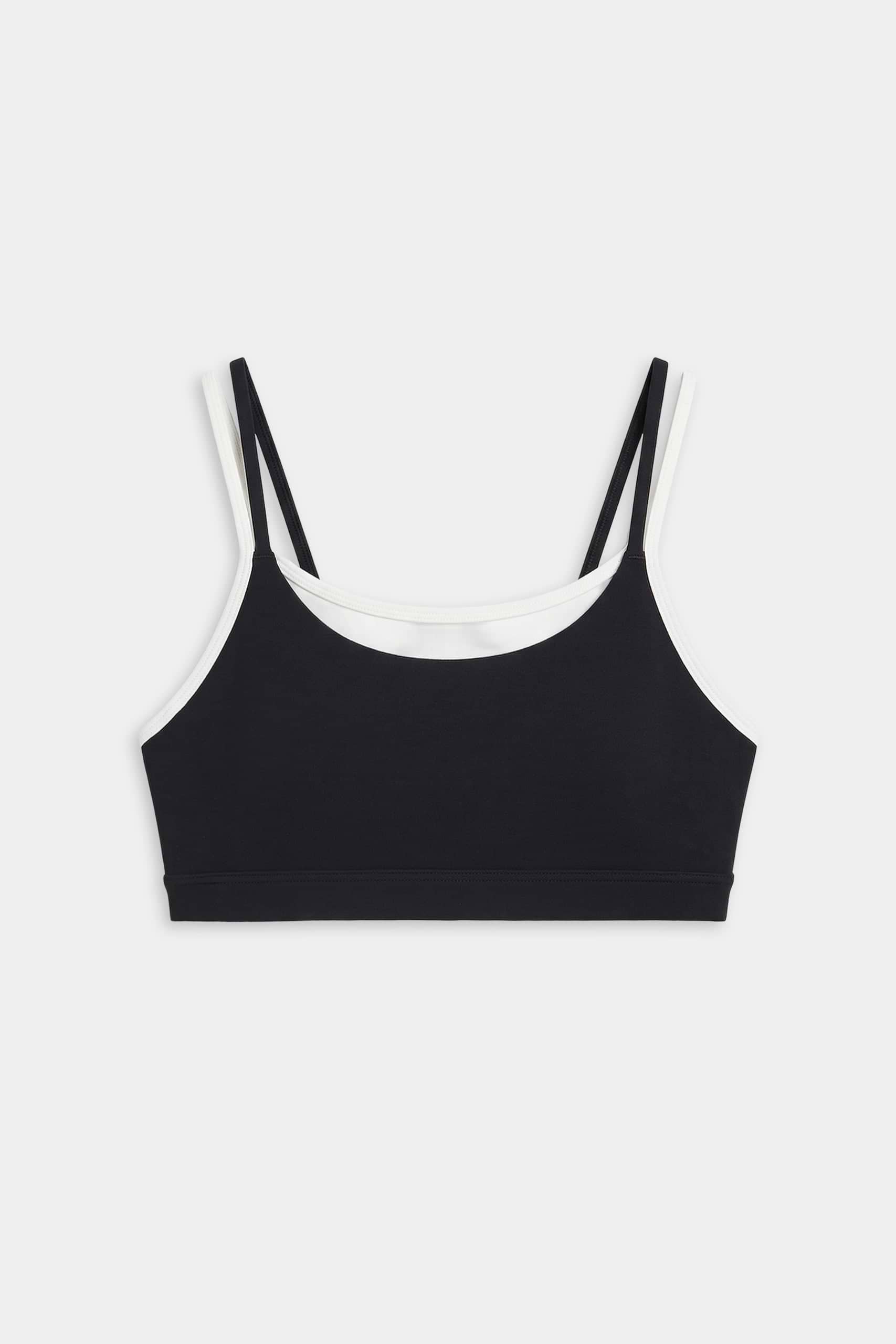 The SPLITS59 Elliah Airweight Double Layer Bra in black/white features double shoulder straps, white trim, and a soft spandex-nylon blend, shown on a plain white background.