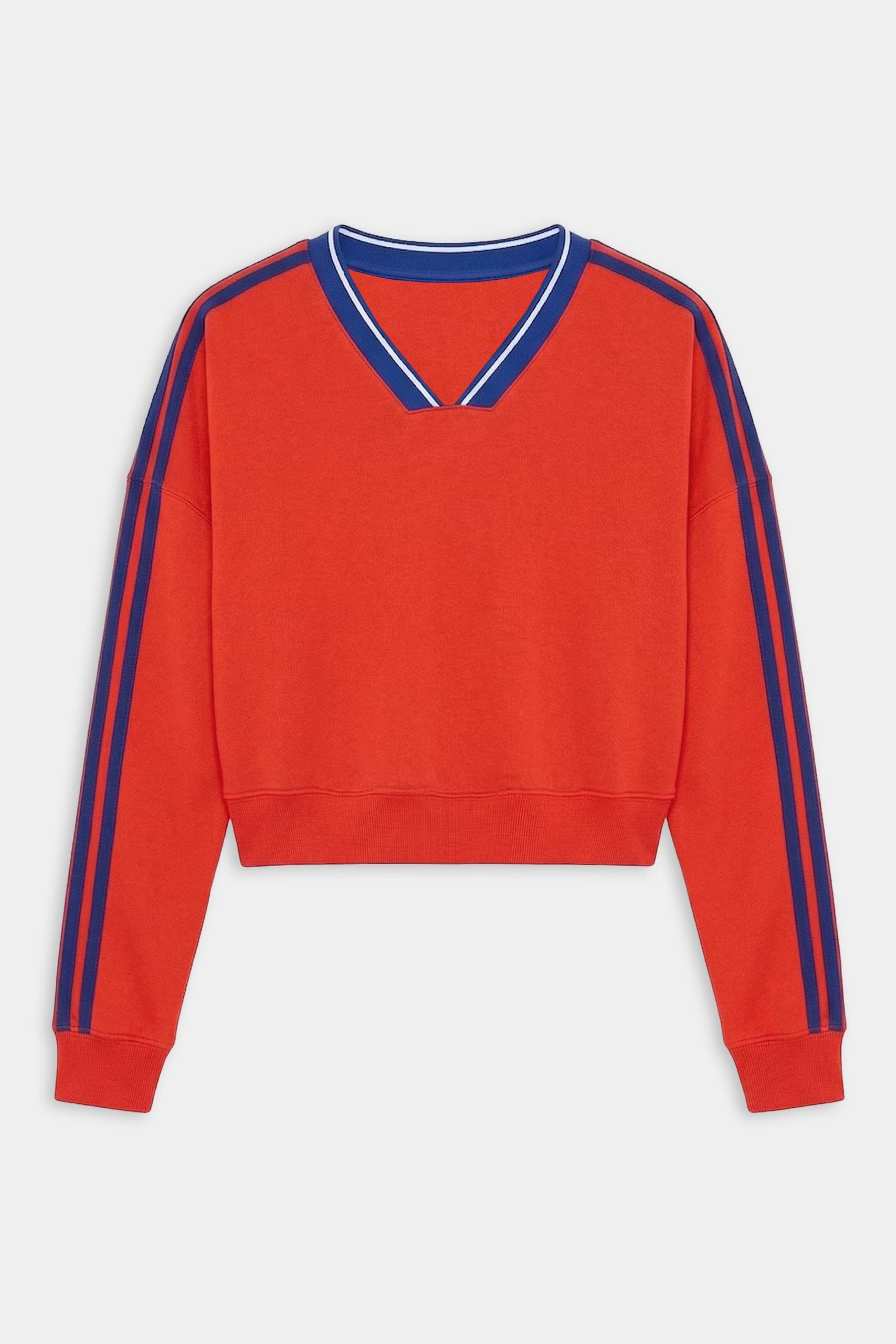 The SPLITS59 Ellie Fleece V Neck Sweatshirt in Lotus Red/Cobalt features blue double stripes on the shoulders and sleeves, a blue-trimmed V-neck, and is made from a soft spandex blend for comfort and stretch.