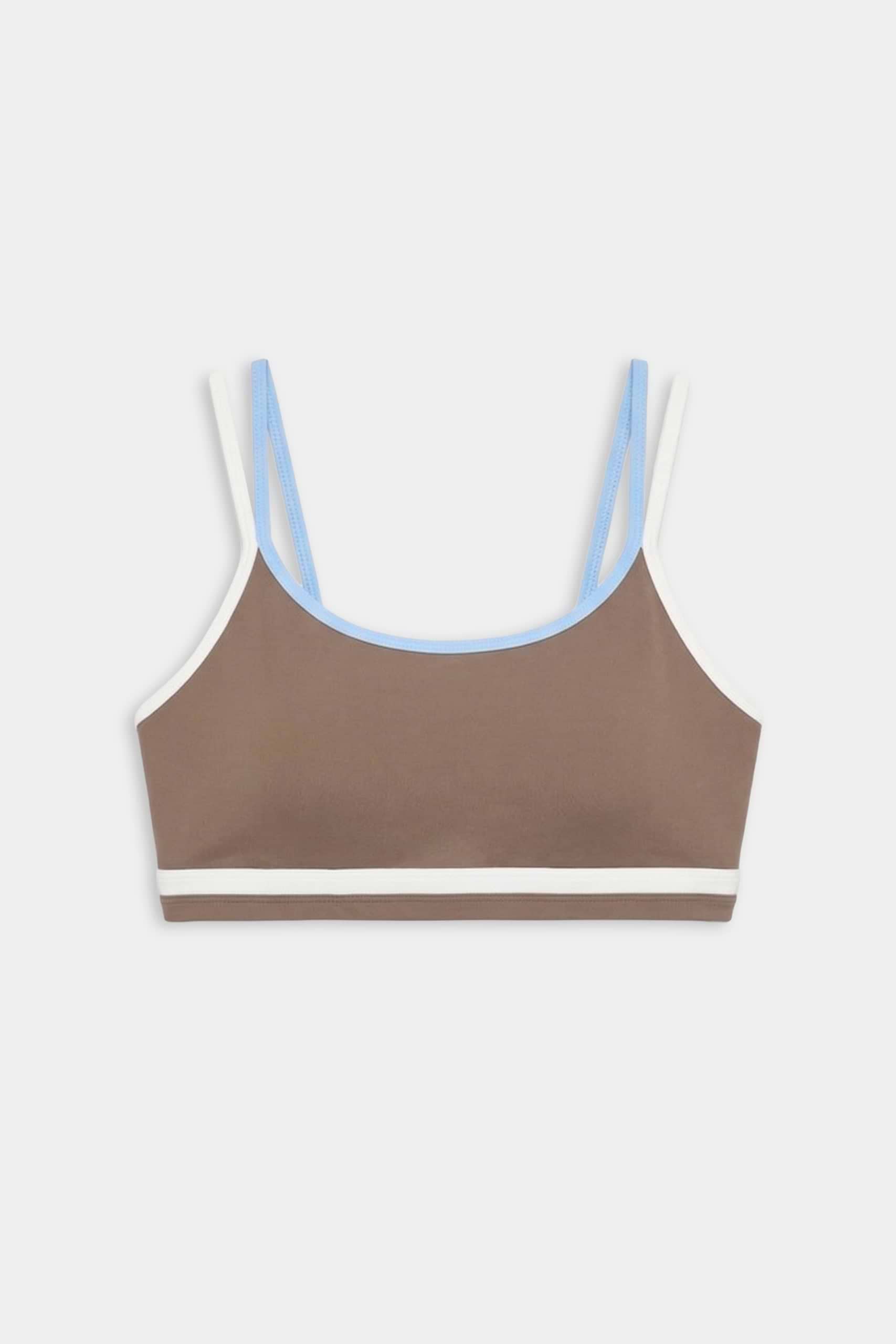 The SPLITS59 Eva Rigor Double Strap Bra in Lentil/White features slim white and blue straps with a white bottom band—ideal for gym workouts, shown against a plain white background.